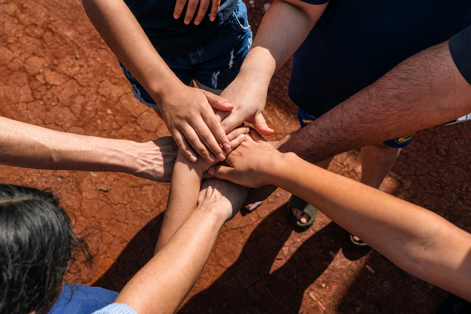 Crianças e voluntários unem as mãos durante uma ação